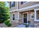 Charming home exterior featuring stone accents, a decorative wreath on the door, and colorful potted flowers at 9066 Apache Plume Dr # E, Parker, CO 80134
