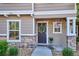 Cozy covered porch featuring a wreath on the front door and decorative flower pots at 9066 Apache Plume Dr # E, Parker, CO 80134