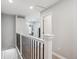 Upstairs hallway with white railing, neutral walls, and carpet, offers a clean transition between rooms at 9066 Apache Plume Dr # E, Parker, CO 80134
