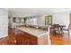 Kitchen island with stone counters, dining area, and hardwood floors at 9066 Apache Plume Dr # E, Parker, CO 80134