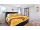 Main bedroom with soft yellow bedding and shuttered window at 9066 Apache Plume Dr # E, Parker, CO 80134