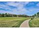Community park featuring grass, walking paths, playground, and open space with buildings in the background at 9066 Apache Plume Dr # E, Parker, CO 80134