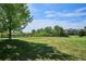 Scenic view of a community park with a grassy field, trees, and walking paths with a fence at 9066 Apache Plume Dr # E, Parker, CO 80134