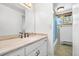 A bathroom features a vanity with a marble countertop, a large mirror, and a shower/tub behind a blue curtain at 11608 Apache Trl, Conifer, CO 80433