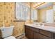 Cozy bathroom featuring unique wallpaper, ample counter space, and a well-lit mirror at 11608 Apache Trl, Conifer, CO 80433