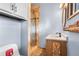 Bathroom featuring wood vanity and wood framed mirror, along with a walk-in shower with tiled walls at 11608 Apache Trl, Conifer, CO 80433