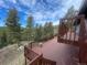 Wooden deck offering scenic views of surrounding trees and a picnic area, perfect for outdoor enjoyment and entertaining at 11608 Apache Trl, Conifer, CO 80433