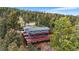 Aerial view of a multi-level home nestled in the trees with an expansive wrap-around deck, perfect for outdoor living at 11608 Apache Trl, Conifer, CO 80433