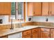 Close-up of kitchen featuring granite counters, stainless steel faucet, and warm wood cabinetry at 11608 Apache Trl, Conifer, CO 80433