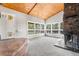 Bright living room featuring a stone fireplace, vaulted wood ceilings, and large windows with scenic views at 11608 Apache Trl, Conifer, CO 80433