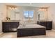 Luxury bathroom featuring a jacuzzi tub, dark wood vanities and beautiful tile at 2702 Rising Moon Way, Castle Rock, CO 80109