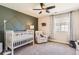 Cozy Bedroom features a modern accent wall, crib, and comfortable chair for a serene environment at 2702 Rising Moon Way, Castle Rock, CO 80109