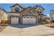 Beautiful two-story home featuring stone accents, three-car garage, and well-kept front yard at 2702 Rising Moon Way, Castle Rock, CO 80109