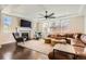 Cozy living room featuring a fireplace, ceiling fan, and large windows for natural light at 2702 Rising Moon Way, Castle Rock, CO 80109