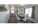 Bright dining room with a modern table and white chairs, flowing into a comfortable living area at 5559 Gibraltar St, Denver, CO 80249
