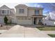 Charming two-story home boasts a tile roof, a covered porch, and a two-car attached garage at 5559 Gibraltar St, Denver, CO 80249