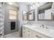 This bathroom offers dual sinks with vanity, tile floors, modern lighting, and silver framed mirrors at 2359 Dogwood Dr, Erie, CO 80516