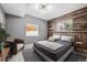 Cozy bedroom with wood-paneled accent wall, plush bedding, and ample natural light at 2359 Dogwood Dr, Erie, CO 80516