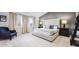 Spacious main bedroom featuring a neutral palette, cozy armchair, and modern decor at 2359 Dogwood Dr, Erie, CO 80516