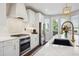 Elegant white kitchen featuring an island with seating, stainless steel appliances, and a modern design at 2359 Dogwood Dr, Erie, CO 80516