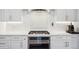 Bright kitchen features stainless steel appliances, white cabinets, designer backsplash, and marble countertops at 2359 Dogwood Dr, Erie, CO 80516