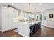 Bright kitchen with a large island and seating, white cabinetry, stainless appliances, and contemporary lighting fixtures at 2359 Dogwood Dr, Erie, CO 80516