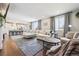 Spacious living room with fireplace opening into the kitchen and featuring hardwood floors and modern furnishings at 2359 Dogwood Dr, Erie, CO 80516