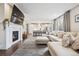 Open-concept living room with fireplace flowing into the kitchen and showcasing a large sectional sofa at 2359 Dogwood Dr, Erie, CO 80516