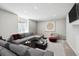 Modern living room with large sectional, stylish decor, and natural light from the window at 2359 Dogwood Dr, Erie, CO 80516