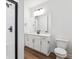 Modern bathroom with a tiled shower, black hardware, wood-look flooring and white vanity at 8601 Yellowcress St, Littleton, CO 80125