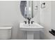 Modern half-bath with a pedestal sink, black hardware, white walls, and modern lighting at 8601 Yellowcress St, Littleton, CO 80125