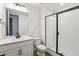Bathroom featuring white cabinets, a glass enclosed shower, and modern fixtures at 8601 Yellowcress St, Littleton, CO 80125