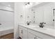 Bathroom featuring double vanity sinks, framed mirror, and white cabinets at 8601 Yellowcress St, Littleton, CO 80125