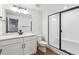 Bathroom featuring dual shower with glass door, white vanity, and square framed mirror at 8601 Yellowcress St, Littleton, CO 80125