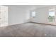 Bright bedroom featuring neutral carpet, white walls and trim, with an ensuite bathroom, and a door to a balcony at 8601 Yellowcress St, Littleton, CO 80125