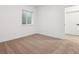 Cozy bedroom with neutral carpet, window, base trim, and white door at 8601 Yellowcress St, Littleton, CO 80125