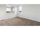Bright bedroom featuring neutral carpet, white walls and trim, and large windows offering natural light at 8601 Yellowcress St, Littleton, CO 80125