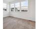 Bright bedroom featuring neutral carpet, white walls and trim, and large windows offering neighborhood views at 8601 Yellowcress St, Littleton, CO 80125