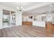 Open dining room adjacent to living room, kitchen, and patio featuring sliding glass doors and modern chandelier at 8601 Yellowcress St, Littleton, CO 80125