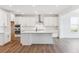 Kitchen with a large center island, stainless hood, and white subway tile at 8601 Yellowcress St, Littleton, CO 80125