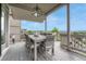 Covered deck with a dining table, seating for eight, string lights, and a scenic view creating an inviting space at 12059 S Tallkid Ct, Parker, CO 80138