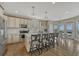 Spacious kitchen with stainless steel appliances, quartz countertops, an island with seating, and a cozy dining area at 12059 S Tallkid Ct, Parker, CO 80138