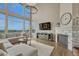 Stunning living room with fireplace, vaulted ceilings, large windows, and hardwood flooring showcasing scenic views at 12059 S Tallkid Ct, Parker, CO 80138