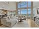 Bright living room with large windows, plush seating, and modern chandelier with hardwood flooring and scenic views at 12059 S Tallkid Ct, Parker, CO 80138