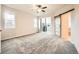 Bedroom with light carpet, a sliding barn door, and balcony access at 5107 S Fairplay St, Aurora, CO 80015