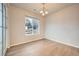 Cozy dining area featuring wood floors, a modern chandelier, and a large window with natural light at 5107 S Fairplay St, Aurora, CO 80015