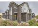 Modern home with a brick exterior, a small balcony, and well-maintained landscaping at 5107 S Fairplay St, Aurora, CO 80015