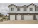 Townhome exterior showcasing attached garages with brick and siding accents at 5107 S Fairplay St, Aurora, CO 80015