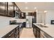 Well-equipped kitchen with stainless steel appliances, dark cabinets, and a functional layout at 5107 S Fairplay St, Aurora, CO 80015