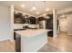 Stylish kitchen featuring a center island, stainless steel appliances, and dark wood cabinetry at 5107 S Fairplay St, Aurora, CO 80015